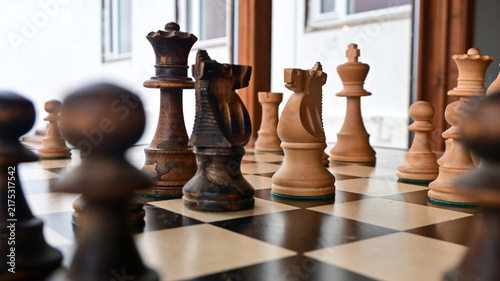 Obraz na plátne A traditional wooden chess game depicting a strategic confrontation between two opposing sides, symbolizing the struggle for territory, resources, political power, tactical planning, and dominance