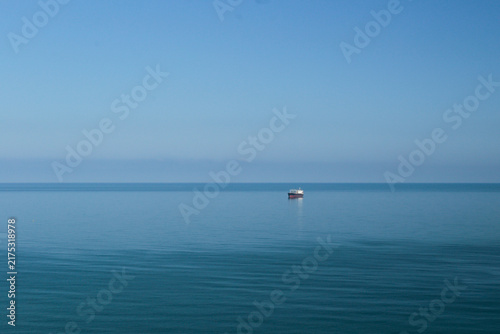 Foto Cargo ship on a calm blue sea