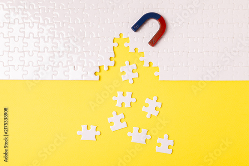 Canvastavla A horseshoe magnet pulling white puzzle pieces across