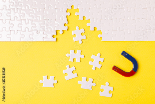 Cuadro en lienzo A horseshoe magnet pulling white puzzle pieces across