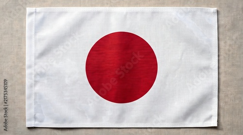 Japanese national flag features a vibrant crimson circle centered on a clean white rectangular fabric banner with textured linen weave