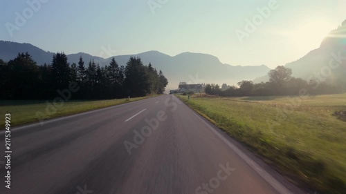 First-person drive POV through Gosau, Austria on a misty morning, alpine village & mountain landscape.