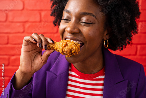 Happy African American Woman Enjoying Delicious Crispy Fried Chicken Drumstick