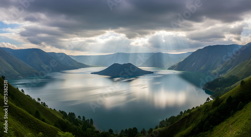 Panoramic view of a lake and mountains under dramatic cloudy sky