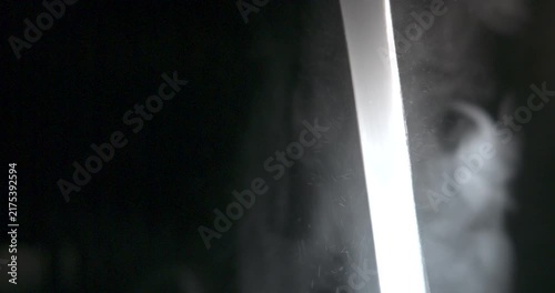 Abstract backlit water stream flowing on black background