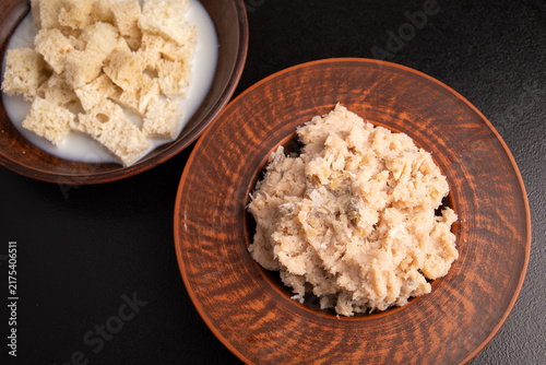 Konstfotografi Raw minced fish on ceramic plate and soaked white bread top view