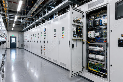 Modern electrical control panel room with rows of distribution cabinets and wiring
