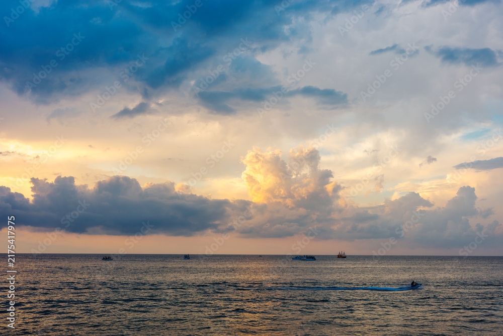 Obraz premium Ocean sunset, dramatic storm clouds, seascape, summer travel, marine recreation, boating, changing weather, scenic coastal background.