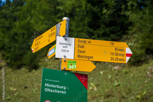 Fotografie Yellow Swiss hiking trail signs showing routes to Axalp, Meiringen, Fluh and Hinterburgseeli in the Bernese Alps