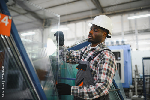 Obraz w ramie African american worker handling glass panel in factory