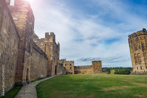 Konstfotografi Medieval Alnwick castle walls and towers under blue sky, UK