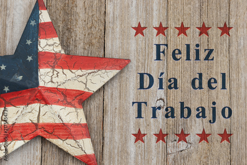 Feliz Día del Trabajo text with retro USA red and blue star on weathered wood for Happy Labor Day