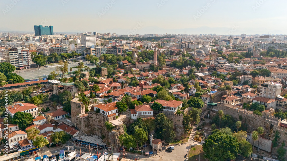 Fototapeta premium Aerial panorama over Antalya's Kaleici old town with red tile rooftops, historic stone walls, mosque minarets and the modern cityscape of Turkey