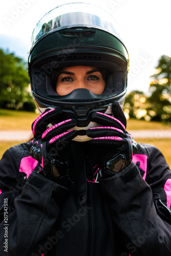 Female biker wearing full face helmet, gloves, and protective jacket