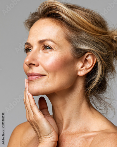 Woman with natural beauty looking up and touching her face
