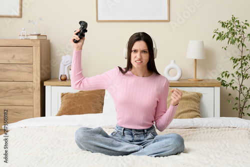 Gaming frustration and competitive stress, angry young woman with headphones ...