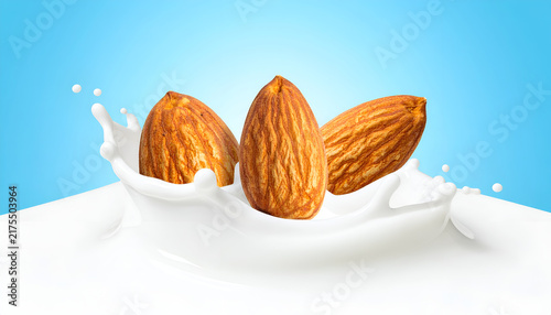 Three almonds are suspended in a splash of milk against a vibrant, gradient blue background. Realistic CGI