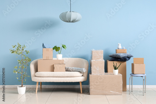 Canvastavla Moving house and relocation concept, cardboard boxes stacked on sofa and floor i