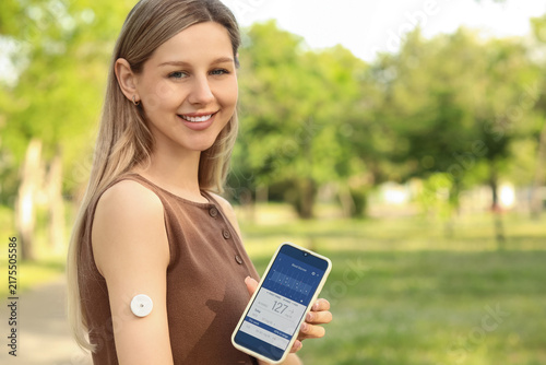 Diabetes management and glucose monitoring, woman using continuous glucose mo...