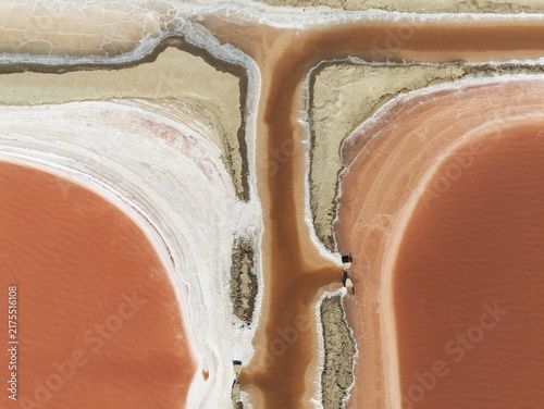 Saline ponds at the Bonanza salt works near Sanlúcar de Barrameda. The reddish colour depends on the level of salinity and is directly caused by the algae Dunaliella salina and brine shrimp. Aerial view. Drone shot. Cádiz province, Andalusia, Spain
