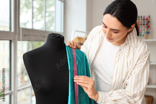 Quadro su tela Female tailor with mannequin working in atelier