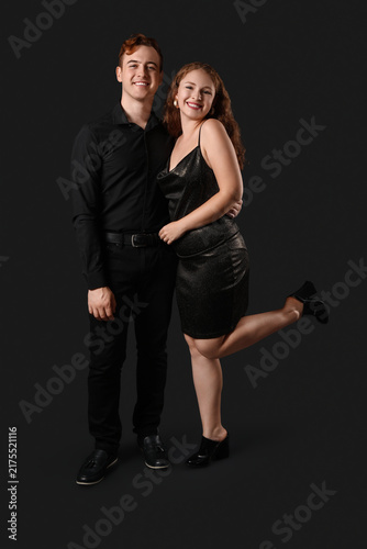 Beautiful young couple on dark background. Black Friday sale
