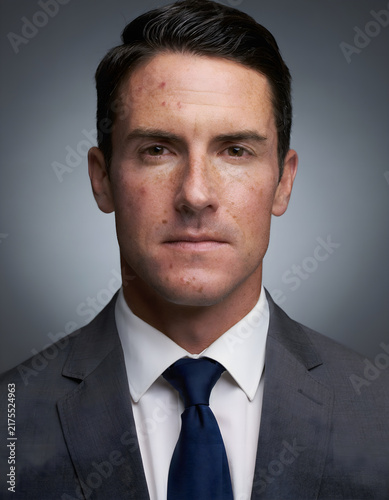 Professional portrait of a confident businessman in a formal suit and tie, photographed against a neutral background with studio lighting, suitable for corporate and business concepts.