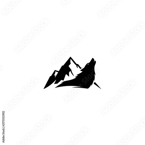 Wolf howling at mountain silhouette
