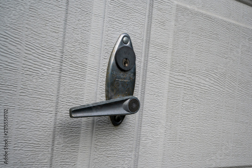 Canvastavla Worn lever handle and keyhole on white vinyl garage door