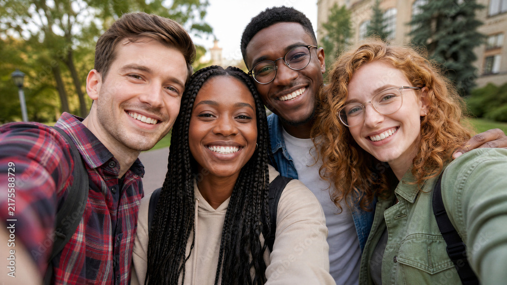 Obraz premium Diverse group of college friends taking a selfie outdoors