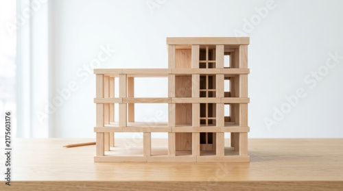 Staffing shortages concept shown by wooden architectural model with open spaces suggesting workforce planning and organizational growth