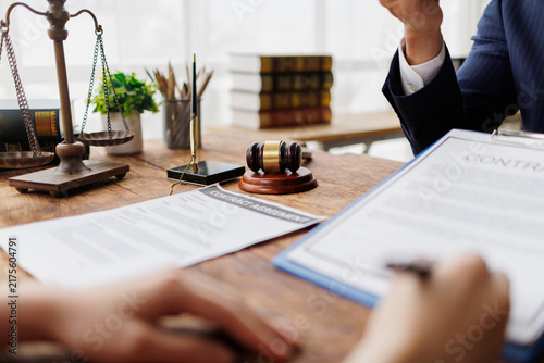 Fotografía Legal professionals discussing and reviewing a contract agreement, with a gavel