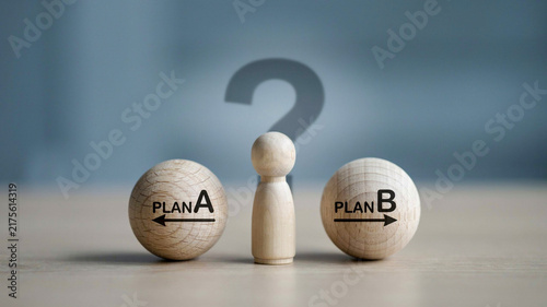 Obraz na płótnie Wooden Figure Deciding Between Plan A or Plan B Direction Options with Question Mark Concept