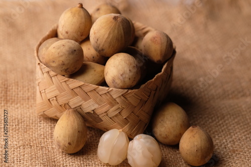 Duku fruit in a woven bamboo container. Tropical fruit. Lansium domesticum. 
