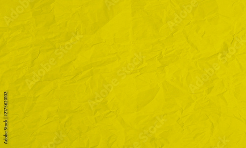 Bright yellow crumpled paper texture background with creased surface pattern.