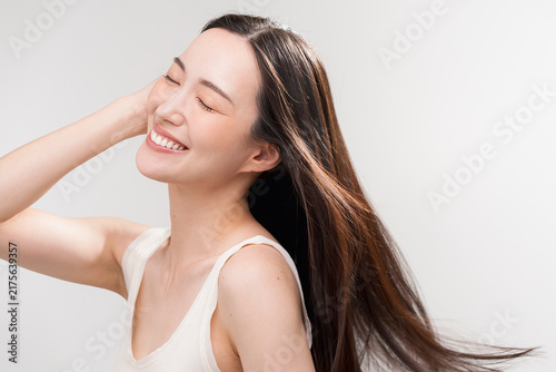 笑顔の日本人女性の長く美しい髪が風になびいている　
