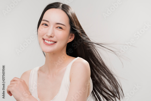 笑顔の日本人女性の長く美しい髪が風になびいている　