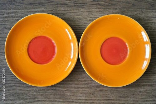 Orange plate on wooden surface, minimal rustic style