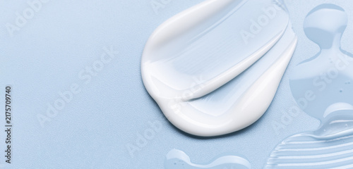 samples of cosmetic care products smear of cream and gel texture on a light blue background