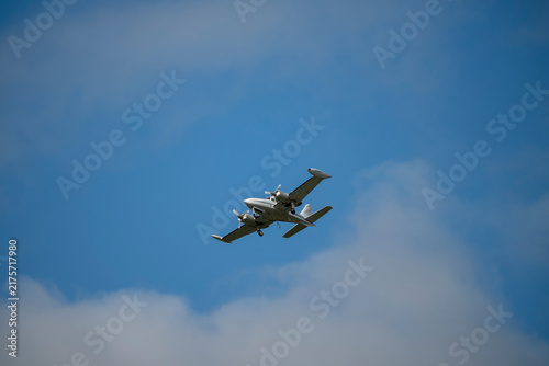 Silver plane glides through clear blue sky