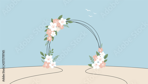 Beautiful wedding floral arch standing on a sandy beach under a clear blue sky with flying birds, ready for a ceremony.