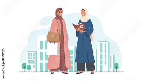 Elegant Muslim women in traditional hijab and abaya chatting on a city street while holding a book and a shopping bag.