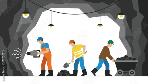 Hardworking coal miners drilling, shoveling, and transporting coal in a cart inside a illuminated dark underground mine.