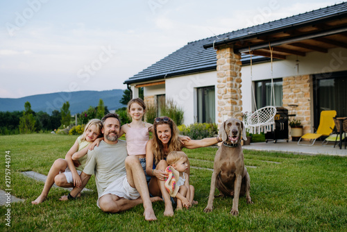 Parents and daughters enjoying late summer together outside family home.