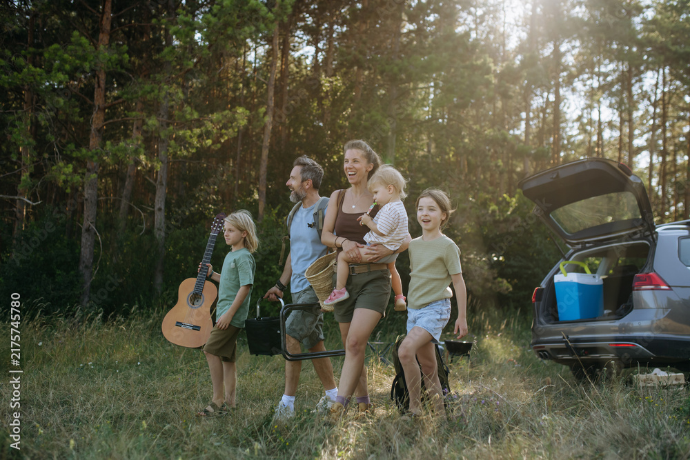 Naklejka premium Family preparing for outdoor camping trip after traveling by car.
