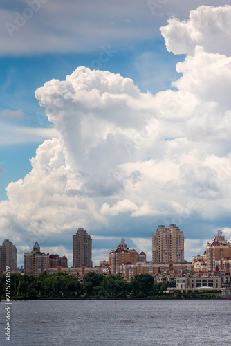 Foto Panoramic view of Kyiv's Obolon district across the Dnipro River, with residential buildings, and dramatic summer clouds