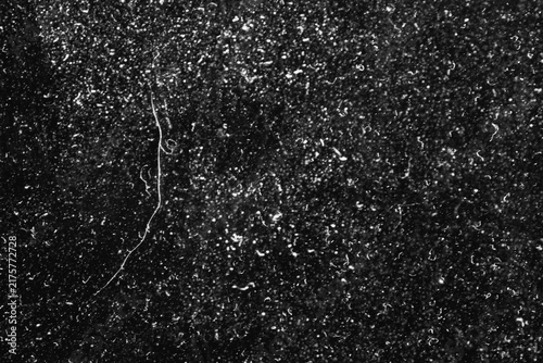 White dust particles and fine fibers scattered across deep black surface for distressed analog texture and grunge overlay