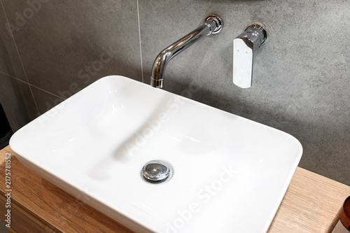 Canvastavla sleek white rectangular vessel sink sits atop light wood countertop
