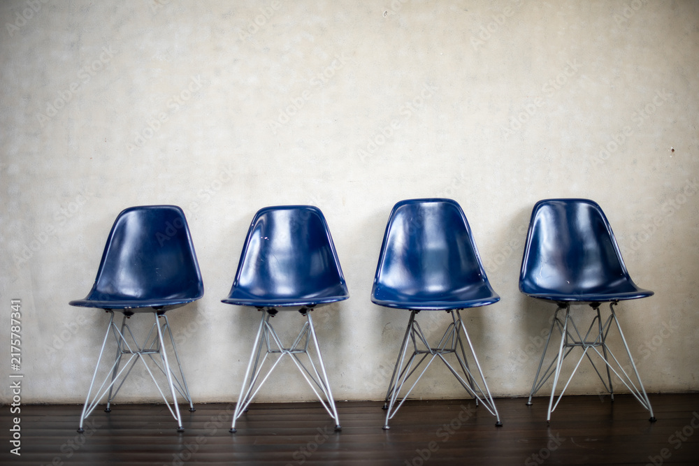 Obraz premium Four blue chairs aligned neatly.