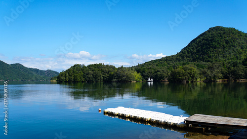 Fototapeta 山影を映す静かな水面と岸辺から伸びる浮桟橋